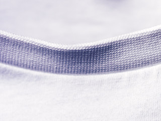 Closeup of the neckline of a white t-shirt. Visible fabric texture, seams.