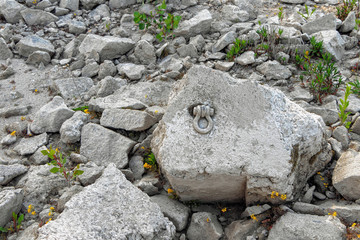 Weathered, mud covered iron eyelet to fasten ships with steel rope