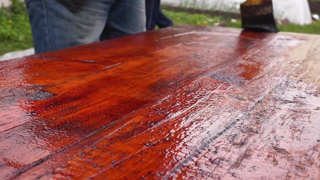 Brush Painting Of Wood. The Application Of Stain On The Boards