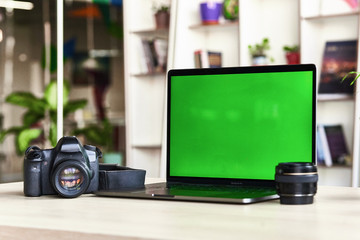 Laptop with mock-up green screen white background in office and Lovely plant in black pot