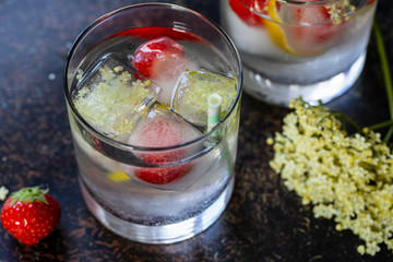 Gin and tonic with eldeflower ice cubes and strawbery garnish