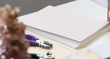Close-up. Decorating tool and stack of sheets for making envelopes