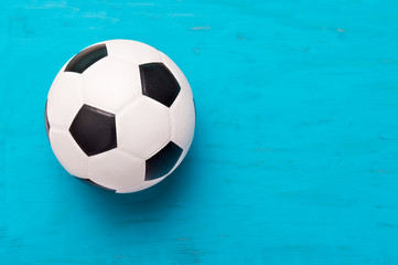 Soccer ball or football on wooden blue background. Online workout concept
