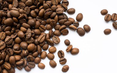 Coffee beans are scattered on a white background, photographed from above