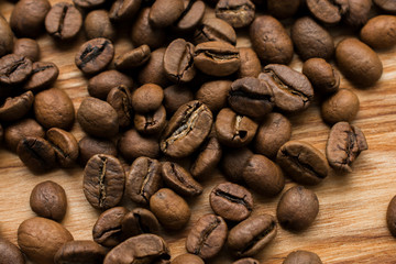 Scattered coffee beans on the wooden surface, strong drink, all over the area