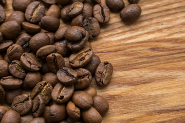 Coffee beans on a wooden background, close-up with free space