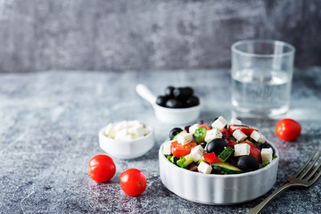 Greek Salad with ingredients in a white bowl