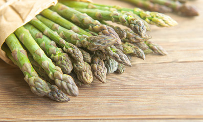 Fresh asparagus sprouts on the wooden background