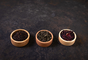 Obraz na płótnie Canvas Tea: green, black, floral. Assortment of dry tea in wooden cups. 