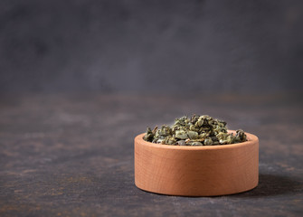 Green tea dry in wooden cup on m with a close-up copy of the space. Healthy organic vitamin herbal tea. - obrazy, fototapety, plakaty