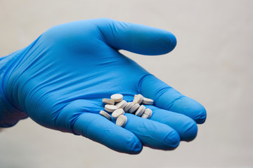 Hand in medical glove takes pill - choice medicine, coronavirus, covid19