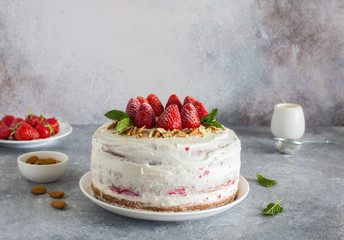 Homemade cake with strawberries, almond flakes and whippedcream close up