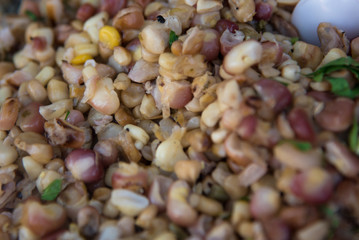 Traditional Mexican Corn Dish Known As Esquites close up,  which is corn cooked in chicken broth with epazote herb and seasoned with mayonnaise, shredded white 