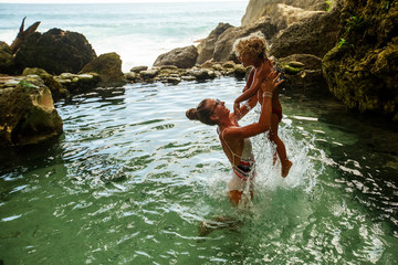 Mom with baby in a natural pool by the ocean