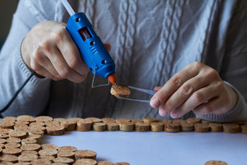 Homemade cork panel, woman makes wine cork note board, selective focus