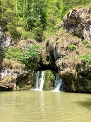 Fototapeta na wymiar Waterfall Beautiful emerald underground lake in the Ural mountains of the Republic of Bashkortostan, Atysh river