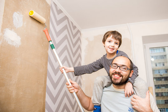 Cheerful Father And Son Hanging Wallpaper Together, Home Renovation, Fun