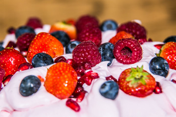 Pavlova dessert with fresh fruit and sweet cream.Closeup