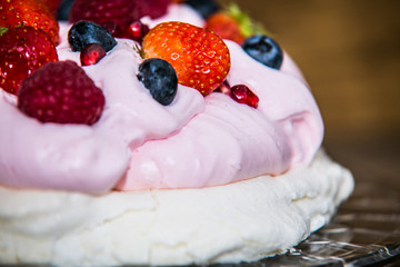 Pavlova dessert with fresh fruit and sweet cream.Closeup