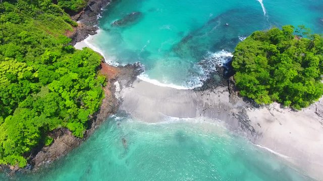 Backwards Flying Aerial View of Cavada Islands (Isla Secas) with Coral and Rock Fringed Clear Water Beaches
