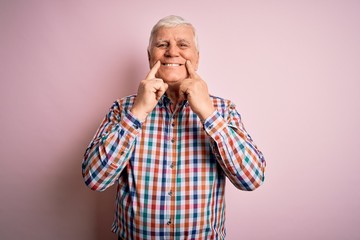 Senior handsome hoary man wearing casual colorful shirt over isolated pink background Smiling with open mouth, fingers pointing and forcing cheerful smile