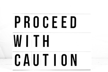 Modern Proceed With Caution Sign on Retro Quote Board. Safety