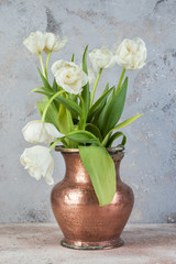 White tulips in old copper vase