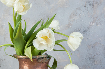 White tulips in old copper vase