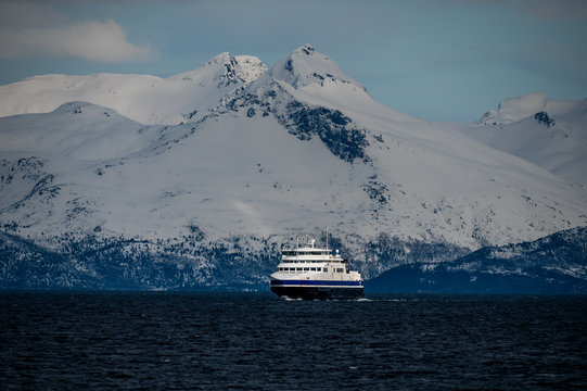The ferry from Bogenes to Lodingen in Norway with the snowy mountains in the background. 