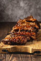 barbecue pork ribs on a wooden board, copy space, close-up