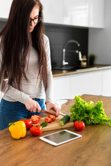 Young trendy woman cooking healthy food in the morning