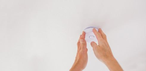 Craftsman installs smoke detectors on white ceiling tested fire detectors formerly artisans fire...