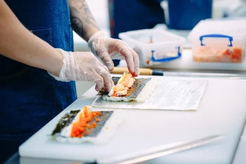 Foto op Plexiglas Sushi delivery. Masked and gloved chefs prepare sushi In the Restaurant's kitchen. © davit85