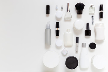 Black and white cosmetics set with brush, lipstick, perfume, shampoo, cream, lotion.