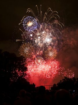 Low Angle View Of People Watching Firework Display At Night