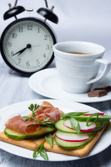 Breakfast with tea and ham and vegetable sandwiches.