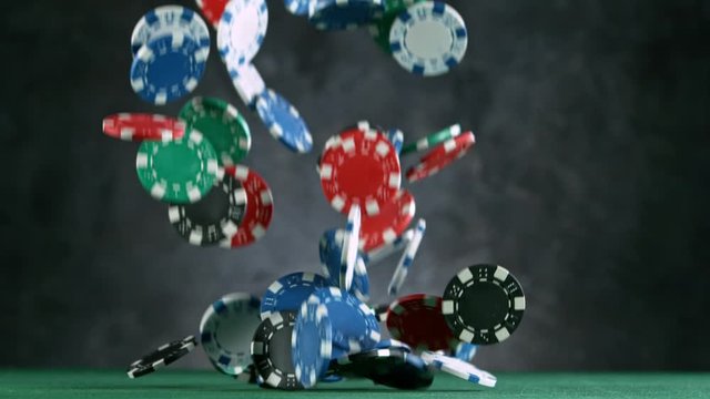 Poker chips falling on casino table in super slow motion, filmed on high speed cinema camera at 1000 fps. Gambling background.