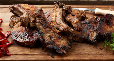 grilled pork steaks on the bone on a kitchen cutting board