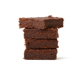 stack of square baked pieces of brownie chocolate cake isolated on a white background
