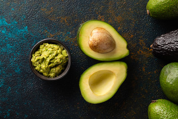 avocado and guacamole on a dark rustic background top view