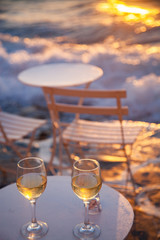 restaurant table by the sea with white wine at sunset summer holiday concept