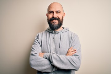 Handsome sporty bald man with beard wearing sweatshirt standing over pink background happy face...