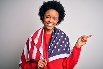 Young African American afro woman with curly hair wearing united states of america flag very happy pointing with hand and finger to the side