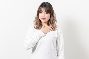 Obraz premium 胸に手を当てる若い女性