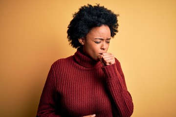 Fototapeta na wymiar Young beautiful African American afro woman with curly hair wearing casual turtleneck sweater feeling unwell and coughing as symptom for cold or bronchitis. Health care concept.