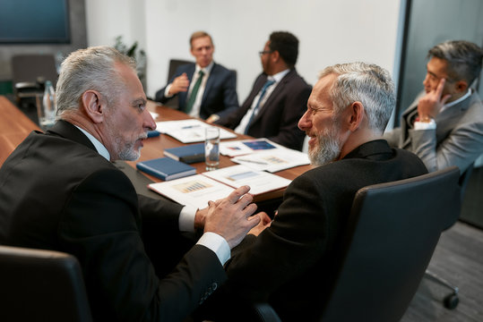 Busy working day. Multicultural business people in formal wear discussing something while having a meeting in the modern office