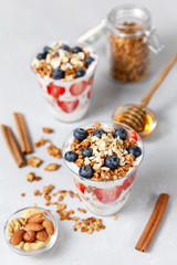 Granola Parfait with greek yogurt, oat cereal, fresh berries, honey in glass jar
