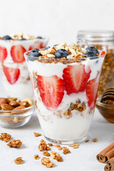 Granola Parfait with greek yogurt, oat cereal, fresh berries, honey in glass jar