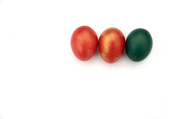 three red and green Easter eggs on a white isolated background