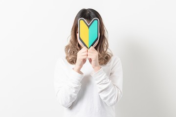 初心者マークを持つ若い女性